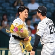 引退セレモニーで阪神の藤川球児監督（右）から花束を贈られる岩貞祐太＝甲子園球場（撮影・吉田敦史）