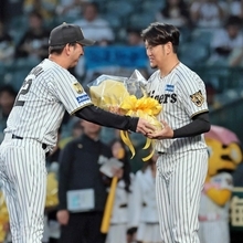 阪神-広島　藤川監督から花束を受け取る岩貞祐太（右）＝甲子園球場（撮影・鈴木雅之）