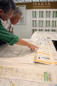 防災士と一緒に地図を見て、自宅周辺の危険箇所や避難経路などを確認できる防災啓発ブース＝さんちか夢広場