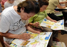 避難マップを見て自宅から緊急避難場所への道のりを確認する住民たち＝兵庫区里山町、高齢者ケアセンターひょうご