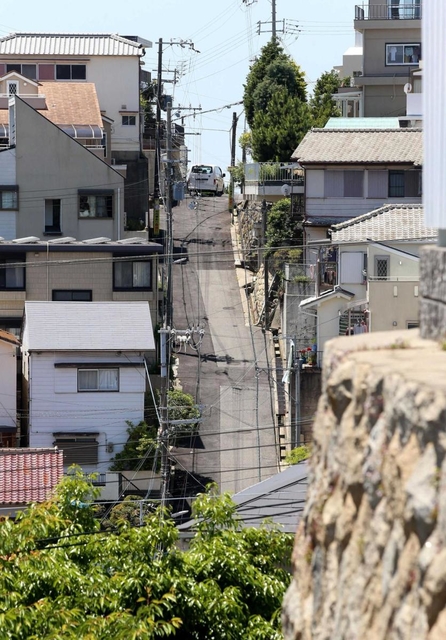 坂の向こうは下り坂。頂点で車は最徐行して進む（撮影・辰巳直之）