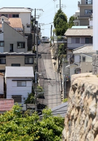 坂の向こうは下り坂。頂点で車は最徐行して進む（撮影・辰巳直之）