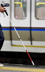 白杖を手に駅のホームを歩く視覚障害者。単独乗車の場合、１００キロを超えなければ割引が適用されない鉄道も多い