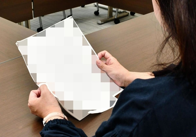 取材に応じる元パート保育士の女性。手元の資料には自身が受けた嫌がらせの内容がまとめられていた＝神戸市内