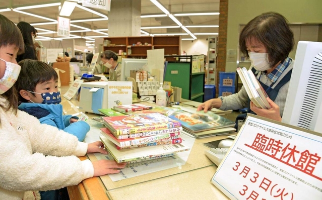 臨時休館に備え、大量の本を借りる子どもたち＝１日午前、神戸市中央区楠町７、市立中央図書館（撮影・後藤亮平）