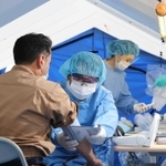 屋外のテント内で発熱患者を診察する医師ら。補助金を受けるには、こうした一般患者との分離対策が必要となる＝４月、西脇市立西脇病院