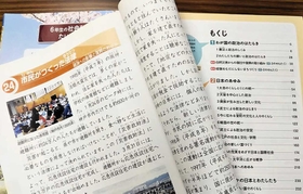 「政治」が目次で最初にある小学６年の教科書。手前は神戸市の副読本「しあわせ　はこぼう」