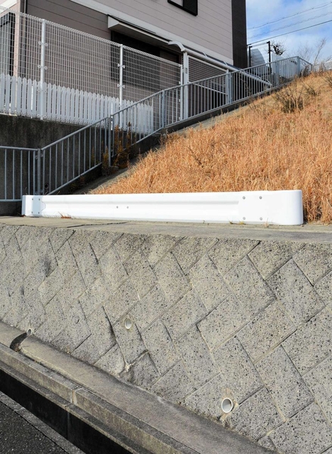 のり面と民家の境目に、一本だけ設置されたガードレール＝神戸市垂水区小束山２