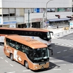 交差点を左折しようとするバス（奥）。横断歩道を渡る歩行者も多く、車の渋滞が常態化している＝神戸市中央区