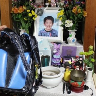 馬越裕都さんの遺影と肩ひもがちぎれたランドセル