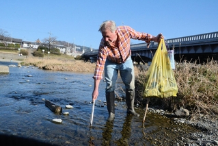 鴨川でごみを探すジャスティン・ギフィンさん＝京都市上京区