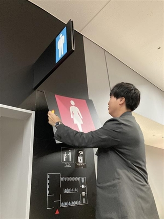 みずほペイペイドームの通路にあるトイレ入り口のピクトグラムはマグネット式で、男女の区分を手軽に変えることができる＝福岡市中央区