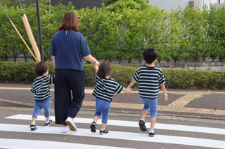 同じ保育施設に通えない双子の息子の手を引く女性（左から２人目）。送迎などの負担は大きく、行政に改善を訴える＝仙台市泉区