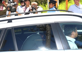 車両の後部座席で顔を伏せて神戸地裁に入る野々村竜太郎被告（手前左）＝６日午後１時４８分、神戸市中央区、神戸地裁前
