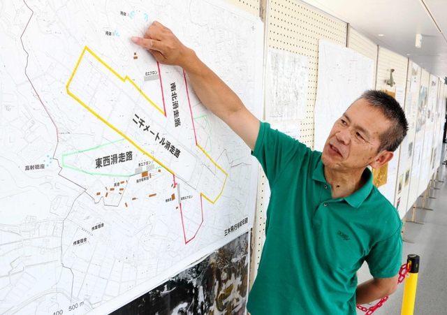 「三木飛行場展」で飛行場の復元図について説明する宮田逸民さん＝三木市立中央図書館