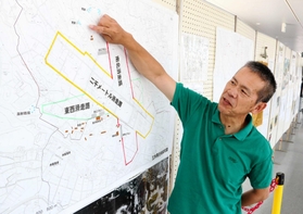 「三木飛行場展」で飛行場の復元図について説明する宮田逸民さん＝三木市立中央図書館