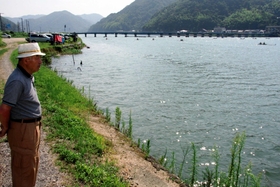 円山川の舟着き場付近に立つ能登茂行さん。当時は城崎大橋がなかった＝豊岡市城崎町今津