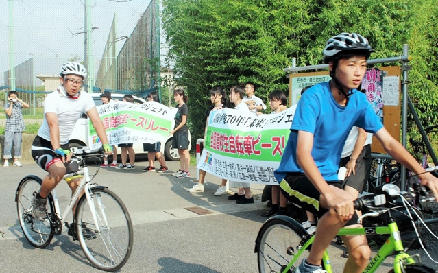 東日本大震災の被災地で採火した「灯」を自転車で運ぶ高校生ら＝宮城県石巻市（主催者提供）