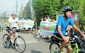 東日本大震災の被災地で採火した「灯」を自転車で運ぶ高校生ら＝宮城県石巻市（主催者提供）