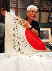 戦後７０年の節目に、特攻に志願した経験を初めて手記にした上山さん。入営の時、父親が墨書した日章旗を今も保管している＝宍粟市一宮町東市場