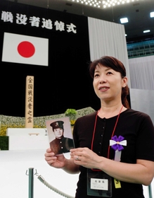 亡き祖父の遺影を手に初めて追悼式に臨んだ納村綾乃さん＝１５日午前、東京都千代田区、日本武道館