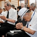 「無念は忘れない」。戦争で散った若い命をしのぶ法要の参列者ら＝春日寺
