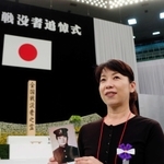 亡き祖父の遺影を手に初めて追悼式に臨んだ納村綾乃さん＝１５日午前、東京都千代田区、日本武道館