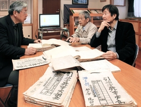 引揚者在外事実申告書を見る藤岡司理事長（右）ら兵庫県海外同友会のメンバー＝神戸市中央区海岸通３
