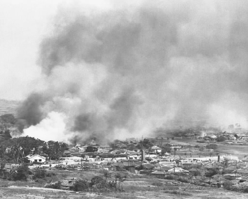 空襲を受け、煙を上げて炎上する市街地＝１９４５年、那覇市（沖縄県公文書館提供）
