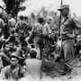 収容所に集められた日本人捕虜を監視する米軍兵＝１９４５年６月２０日、沖縄県（県公文書館提供）