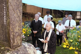 毎年、自決の日には遺族らが慰霊碑の前で犠牲者の冥福を祈る。手前中央に山下さん、左後方に石坪さん＝２０１４年８月１７日、豊岡市但東町久畑、一宮神社