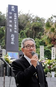 「島守の塔」の前で神戸から訪れた児童らに平和の尊さを訴える嘉数昇明さん＝沖縄県糸満市摩文仁