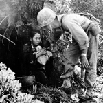 避難していた壕から米海兵隊員に保護される母子＝１９４５年５月、沖縄県内