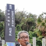 「島守の塔」の前で神戸から訪れた児童らに平和の尊さを訴える嘉数昇明さん＝沖縄県糸満市摩文仁