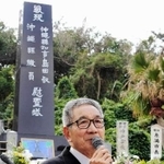 島守の塔の前で講話する製作委員長の嘉数昇明さん＝糸満市摩文仁（２０１５年）
