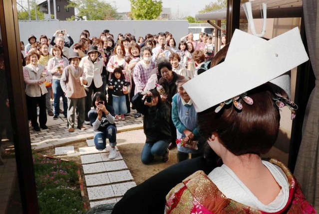 花嫁の姿を一目見ようと、新郎宅の庭に集まった近所の人たち＝南あわじ市北阿万伊賀野