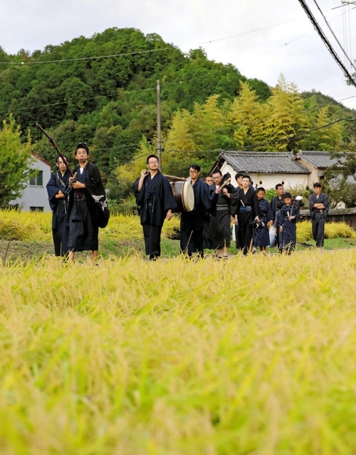 山田錦が実るあぜ道を歩き、村から神社へ向かう宮座の「若衆」と「清座」＝加東市上鴨川