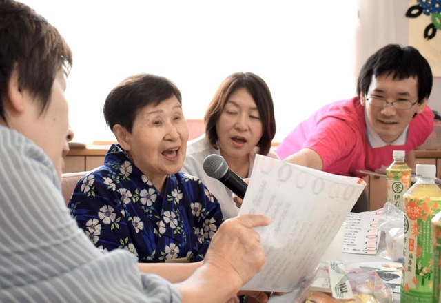 夏祭りで親戚らと一緒に歌を歌う堂脇千鶴代さん＝加古川市野口町水足、グループホームにしむら
