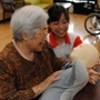 楽しげに「テレノイド」と会話する女性（左）＝尼崎市下坂部、「ゆめパラティース」