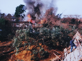 仁川の対岸から見た西宮市仁川百合野町。土砂の下から炎が噴き出した＝１９９５年１月１７日午前（読者提供） 