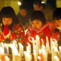 ともされたろうそくをじっと見つめる子どもたち＝１６日午後６時１０分、伊丹市の昆陽池公園 
