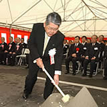 工事の安全を祈り、くわ入れをする稲垣嗣夫神戸新聞社長＝神戸・三宮