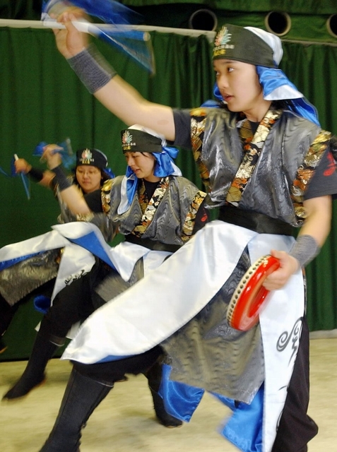 故郷・長田で沖縄の仲間たちとエイサーを踊るなおちゃん（左奥）＝３月６日、神戸市長田区若松町５