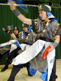 故郷・長田で沖縄の仲間たちとエイサーを踊るなおちゃん（左奥）＝３月６日、神戸市長田区若松町５