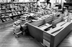 １９９５・７・１９　倒れたままの書架の前で続けられた図書の整理＝神戸市須磨区、市立須磨図書館