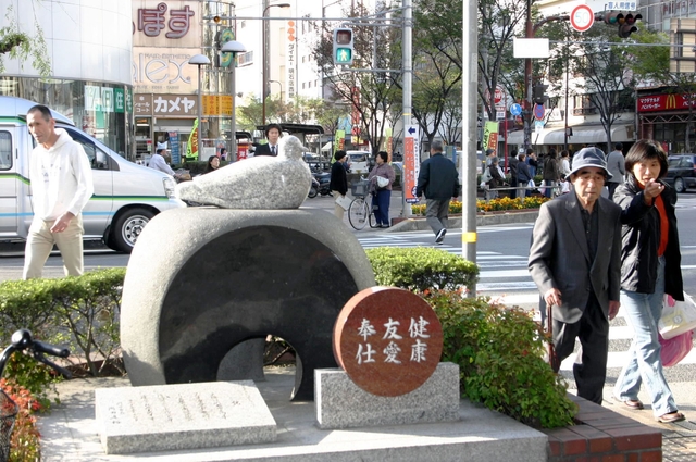 台座上のハトが買い物客を見守る＝明石市桜町 
