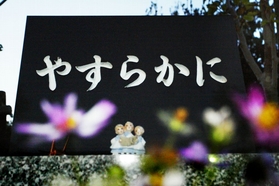 慰霊碑の前には花が絶えない。「やすらかに」。住民の祈りを込めて＝西宮市の仁川百合野町地すべり資料館