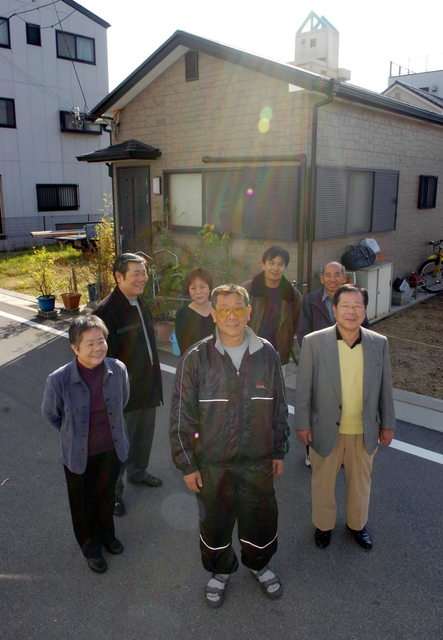 ２００４・１２・１　兄弟、友人に囲まれる文夫さん（中央）＝神戸市長田区御蔵通
