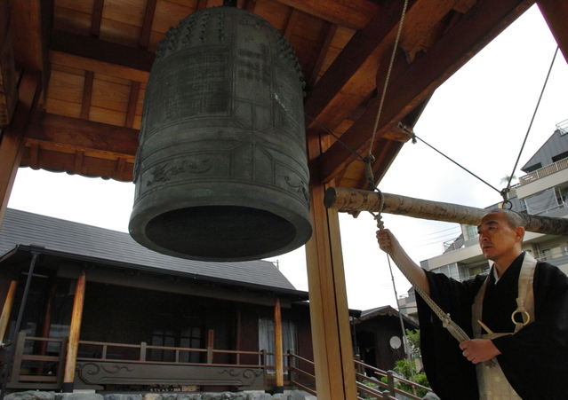 ２００４・１１・１９　再建された鐘楼で鐘をつく関住職＝神戸市灘区岩屋中町４、龍泉寺