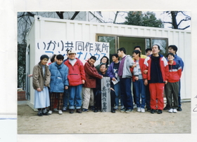 再開した仮設コンテナ前に集まったいかり共同作業所のメンバーたち。笑顔がこぼれる（１９９５年３月）